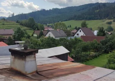 Zrekonštruovaný komín s nerezovou vložkou a dažďovou hlavicou na streche vidieckeho domu